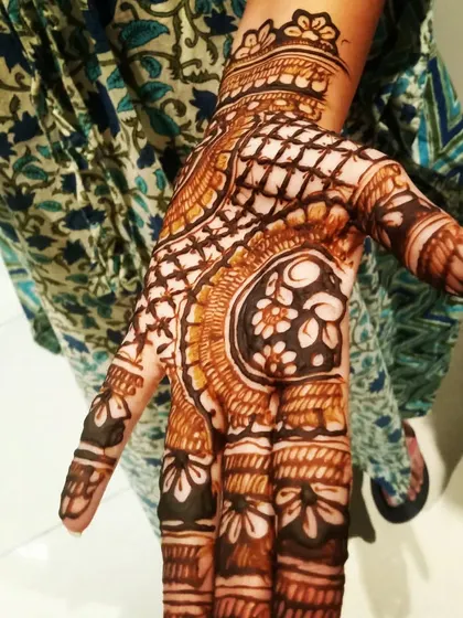 A close-up of a bold and beautiful design for a guest. The contrast between the dark-filled flowers and the fine net pattern makes it very eye-catching.