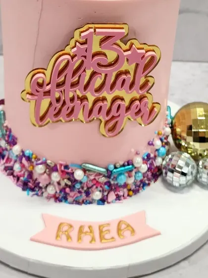 The details on this 13th birthday cake are all about fun, from the custom name plaque to the colorful sprinkle border.