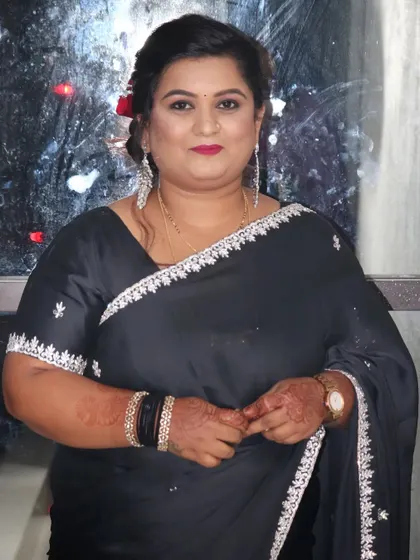 Another party look for Ashritha, this time in a classic black saree. The makeup is glamorous with a bold red lip and a sophisticated hair updo.