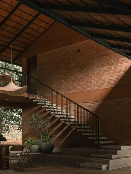 The play of light and shadow on the exposed brick wall and concrete staircase. This angle highlights the clean lines of the metal railing and the texture of the natural building materials.