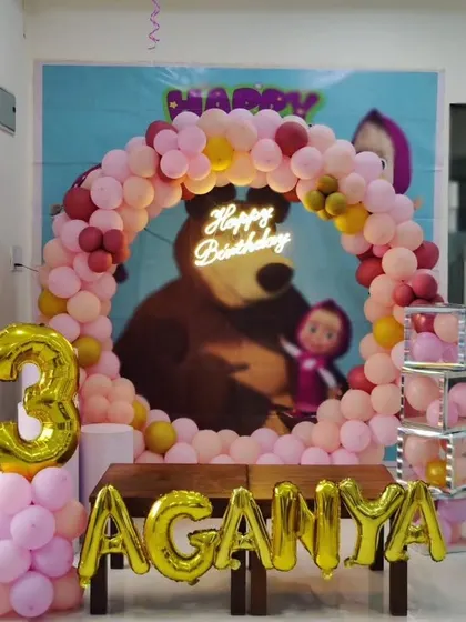 A "Masha and the Bear" themed 3rd birthday party, featuring a circular balloon arch, neon sign, and foil name and number balloons.