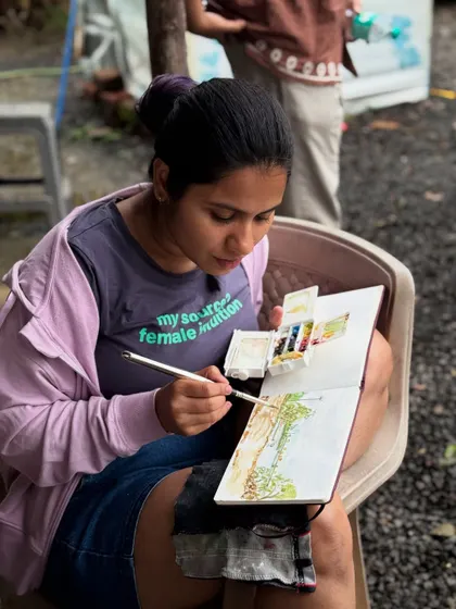 Focused on my sketchbook, trying to capture the lush greenery of a rainy landscape. Plein air painting is my form of meditation.