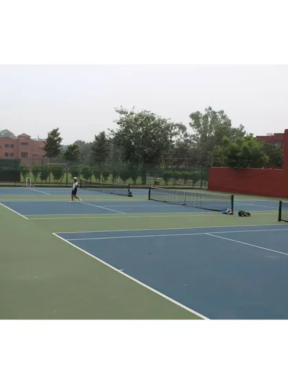 A view across the net during a doubles match, highlighting the layout of our multi-court facility. We provide the complete infrastructure needed to host successful tennis events.