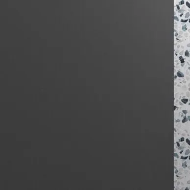 The junction of the plain grey wall and the patterned terrazzo, showing a clean design transition.