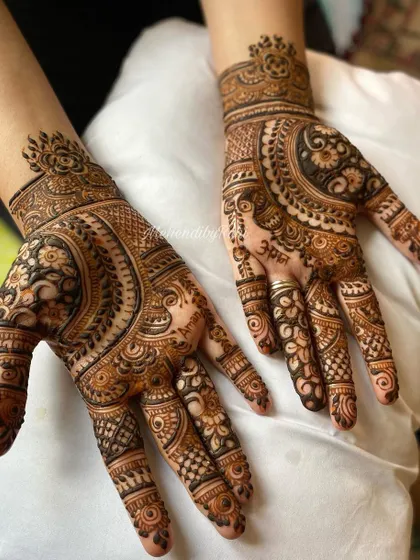 This design features a beautiful flow from the wrist to the fingers, combining circular motifs with leafy patterns.