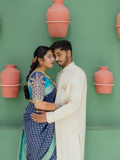 An artistic portrait of a couple against a minimalist green wall with terracotta pots. I love finding unique and creative backdrops for photos.