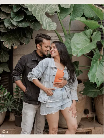 A sweet, natural moment between a couple, framed by lush greenery found in a quiet corner of the city.