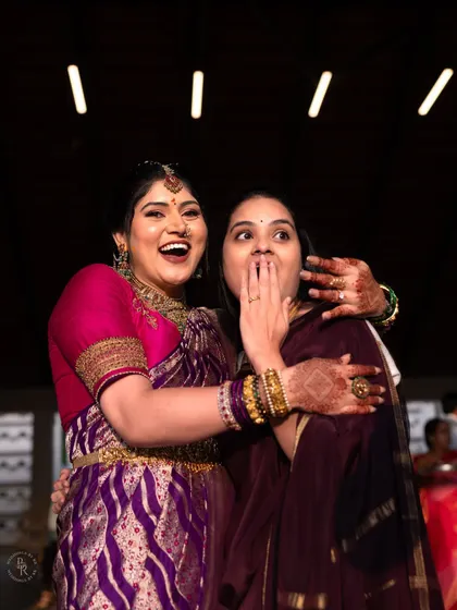 A candid shot of the bride sharing a moment of pure joy and surprise with a friend or sister at her engagement.