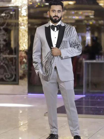 A full-length view of our stylish silver-grey tuxedo with black embroidery. It’s a complete look that is both sophisticated and ready for the party.