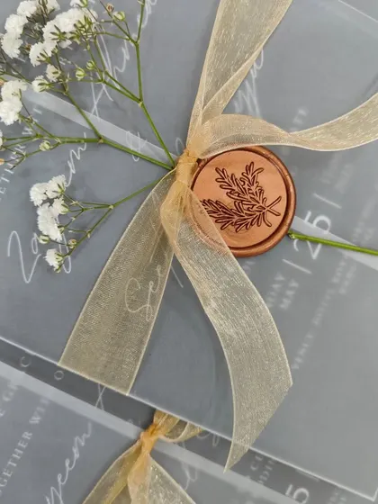 A close-up on the wax seal and baby's breath, showcasing the handcrafted details that make each invitation a unique piece of art.