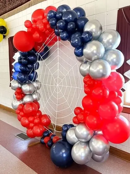 A Spider-Man inspired ring decoration. I used red, blue, and silver balloons to create the frame, with a spider web in the center to complete the superhero theme.