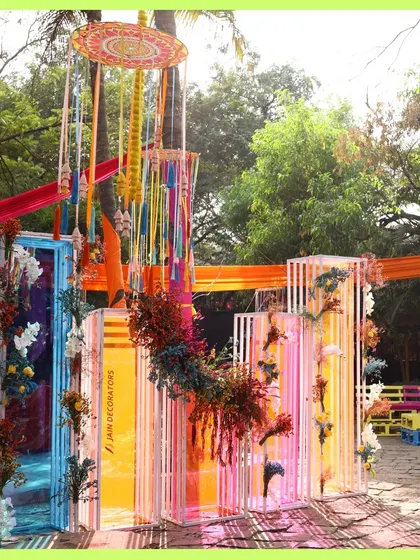 A vibrant and artistic photo backdrop. These colorful translucent panels are adorned with flowers, creating a unique and modern look for a daytime event.