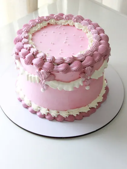 A beautiful pink Lambeth-style cake with detailed, over-the-top piping for a romantic, vintage feel.