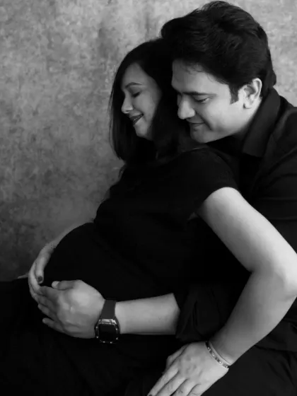 The protective embrace of a partner. This black and white shot emphasizes the emotional support and shared responsibility of parenthood.