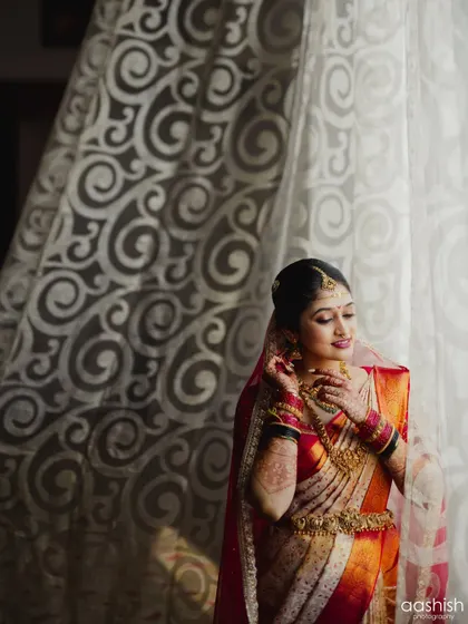 A beautifully lit portrait of the bride by a window. The natural light catches the subtle shimmer on her eyelids and the glow of her skin.