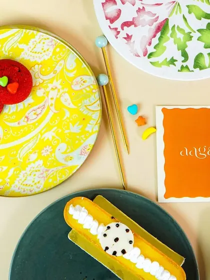 A top-down flatlay of colorful, hand-painted plates styled with fun, artistic pastries. This vibrant and creative shot is ideal for social media content.