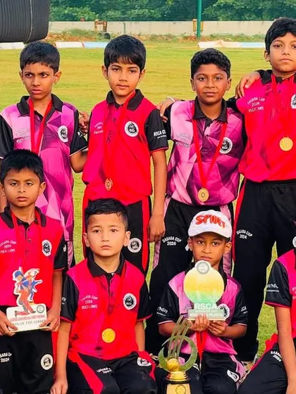 A junior team proudly displays their medals and trophies after a successful tournament.