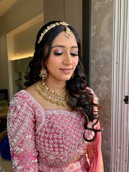 Pink glam for this sangeet look, with a focus on shimmery pink eyeshadow and voluminous curls.
