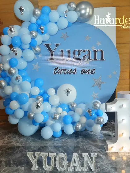 A 'Twinkle Twinkle Little Star' theme for a first birthday. The blue and silver balloon garland on a circular backdrop is paired with a marquee number '1'.