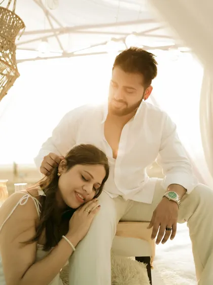 A peaceful moment of rest during a bohemian-style beach picnic setup for a pre-wedding shoot.