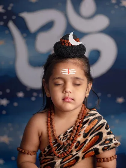 He is all and everything, he is the universe. A little girl meditates deeply, embodying the serene power of Lord Shiva.