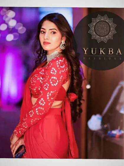 A stunning shot of the client in her red lehenga-saree. The full-sleeved blouse with its tie-back detail makes for a chic and fashionable statement.