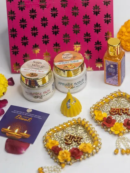 A beautiful Diwali hamper featuring our Mud Face Pack, Apricot Scrub, Abhyanga oil, and a Modak-shaped candle, complete with decorative 'Shubh Labh' hangings.