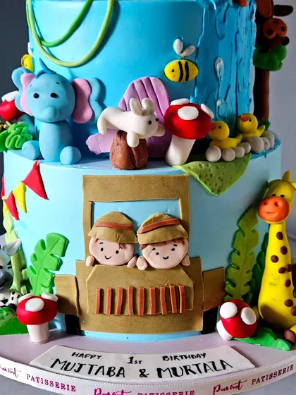 A close-up of the base of the large jungle safari cake, showing the two little explorers in their jeep, ready for an adventure.