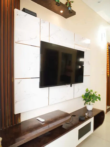 A modern TV unit with a white marble-paneled wall and a sleek, low-profile console. The design is clean, sophisticated, and perfect for a contemporary home.