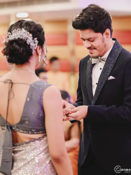The moment of the ring exchange, shot from over the bride's shoulder to focus on the groom's expression.
