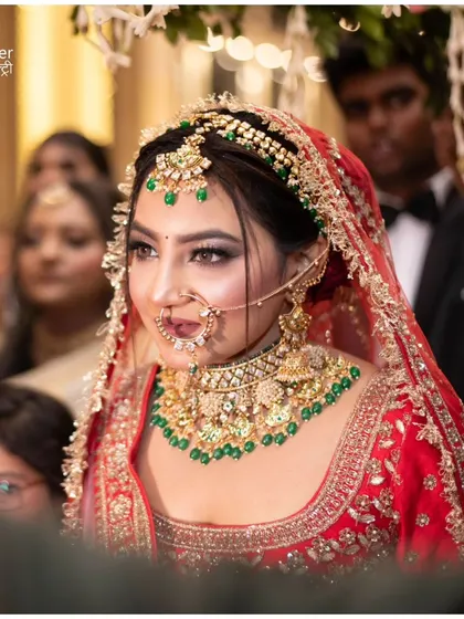 A classic bridal portrait taken during her entrance. The focus is on her stunning jewelry and the happy, confident expression on her face.