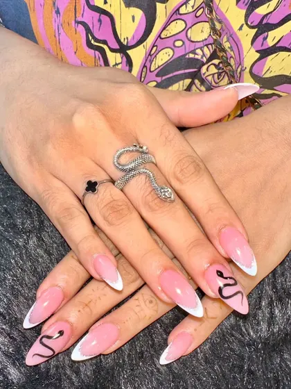 A chic and edgy take on the French manicure. I added delicate, hand-painted snakes to these classic white-tipped stiletto nails for a subtle yet striking detail.