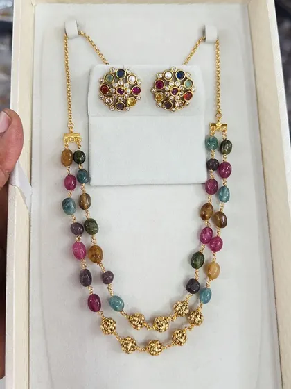This colorful beaded necklace set features a variety of semi-precious stones, making it a vibrant and unique accessory. The matching multi-color studs complete the look.
