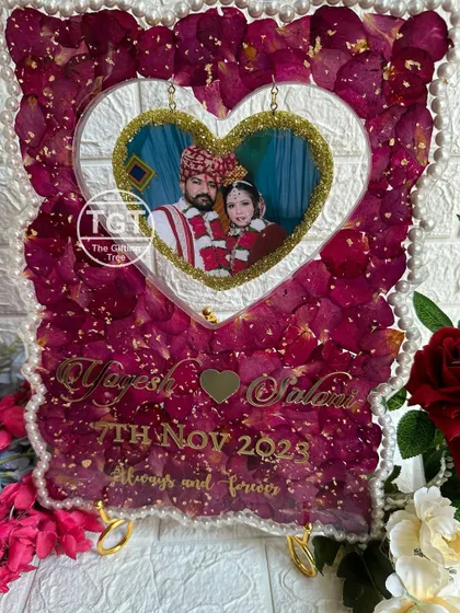 The full view of the heart cutout frame, filled with preserved red rose petals from the couple's varmala and bordered with elegant pearls.