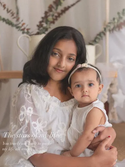 "The stars of my life." An older sister holds her baby sibling close, a beautiful portrait of their developing bond.