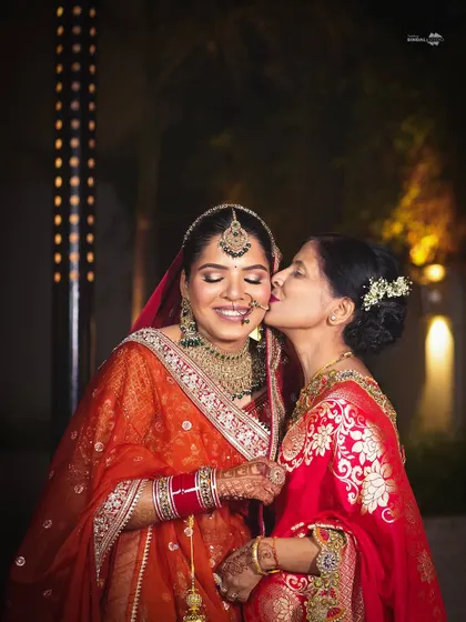 A precious, candid moment of a mother kissing her daughter, the bride, on her wedding day. A picture of pure, unconditional love.