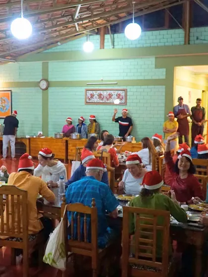 Our community enjoying a Christmas Eve feast together, complete with Santa hats. It is a time of peace, joy, and connection.