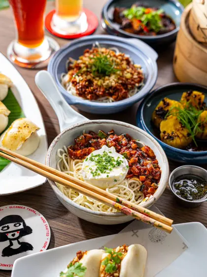 A bowl of Dan Dan noodles as part of a larger spread. This image showcases how we balance individual dish highlights within a full table setting.