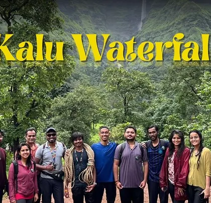 A group photo with the Kalu Waterfall in the background. Trekking in the monsoon means lush greenery and flowing cascades.