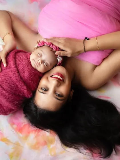 A beautiful overhead shot of a mother and her newborn daughter, lying on a bed of flowers. This artistic composition celebrates the beauty of motherhood.
