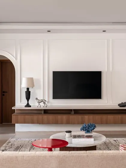 This living room from 'Project Dolce' was designed for a young family, blending contemporary style with practical needs. The space features clean lines, wall paneling for texture, and a floating console to maintain an open feel, proving that a family home can be both sophisticated and functional.