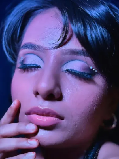 A close-up of the eye makeup under moody lighting, highlighting the shimmer on the lid and the precise liner work.