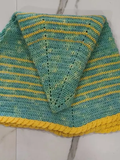 A folded view of the green and yellow shawl. You can see the "lemon frosting" edging I added, which provides a fun, textured border.
