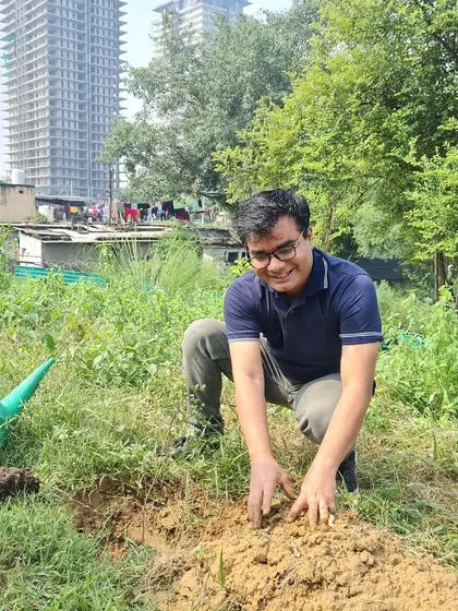 A volunteer from NatWest gets his hands dirty, planting a native sapling at Ghata Bundh to help restore the historic embankment's ecological function.