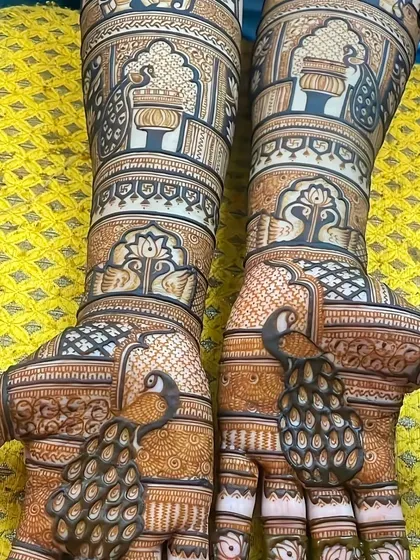 A classic peacock design on the palms, with the feathers flowing down the fingers. The forearms feature traditional patterns in bands.
