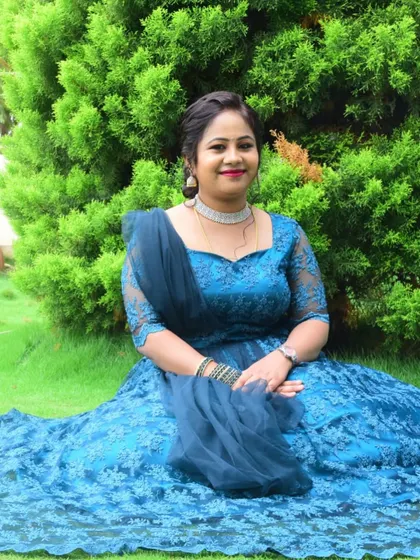 The mother looking elegant in her custom blue lace gown, designed for her son's special day.