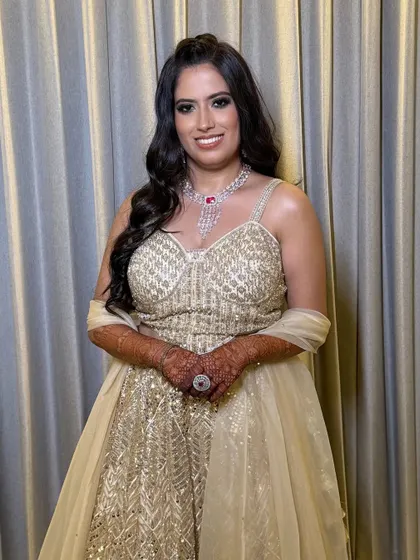 A happy bride, her makeup looking flawless and radiant. The statement ruby necklace is the perfect accessory.