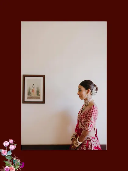 A minimalist and artistic portrait of a bride in profile, standing against a plain wall with a small framed picture, creating a sense of quiet elegance.