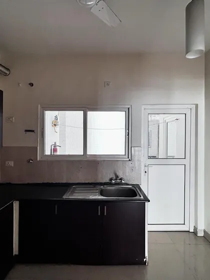 The 'Cover me in Sunshine' kitchen before renovation, showing the original sink placement and utility door.