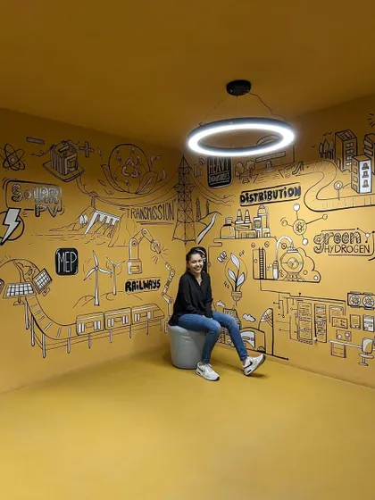 Taking a seat in the finished doodle room at the Amara Raja office. The yellow, black, and white color scheme is my favorite for creating impactful doodle art.